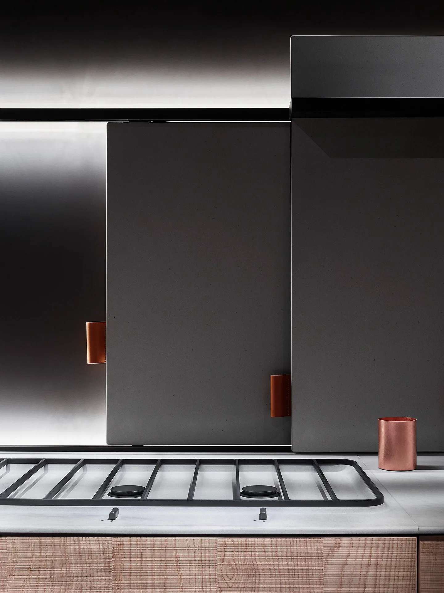 Gas hob on a white marble top, grey doors with leather pulls, a copper beaker and wooden base — Wallpaper editorial, Filippo Piantanida Studio